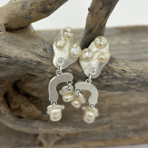 18K gold plated over 925 sterling silver stud style earrings with a satin finish.  Featuring six White Freshwater Rice' shape pearls on each earring, 5-7mm, fragmented over the design, with Cubic Zirconia highlights.  They are 50mm in total length from top to bottom.  Available in silver or gold
