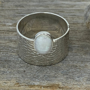 Sterling Silver, textured wide band Ring featuring an offset white mabe/ blister pearl.  The pearl is bezel set and is 8 x 10mm in size  Size 11 only available