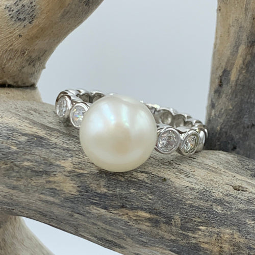 VSterling silver ring featuring bezel set cubic zirconia along the shoulders.  It features a 9.5mm White freshwater pearl Button in shape.  This ring has an antitarnish finish  Various sizes available 