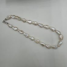 Load image into Gallery viewer, This gorgeous seedless pearl strand looks a little like pear shapes.  It features white with high lustre,&nbsp; 12 x 20mm pearls that have no nuclei so are quite flat in shape. They sit perfectly on any neck.  This strand is fully knotted and features a rhodium coated non tarnish Sterling silver clasp.  The length including clasp is 44cm.
