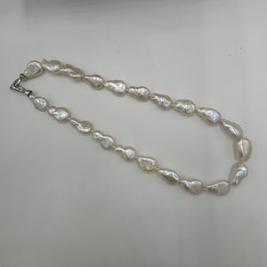 This gorgeous seedless pearl strand looks a little like pear shapes.  It features white with high lustre,&nbsp; 12 x 20mm pearls that have no nuclei so are quite flat in shape. They sit perfectly on any neck.  This strand is fully knotted and features a rhodium coated non tarnish Sterling silver clasp.  The length including clasp is 44cm.