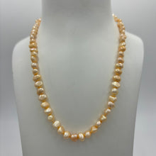 Load image into Gallery viewer, This apricot/gold color Freshwater pearl strand is very subtle and can easily be layered or worn on its own.  It features featuring 5 x7mm &#39;popcorn&#39; pearls with a Sterling Silver clasp and is fully knotted.  The length including clasp is 43cm.
