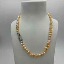 Load image into Gallery viewer, This apricot/gold color Freshwater pearl strand is very subtle and can easily be layered or worn on its own.  It features featuring 5 x7mm &#39;popcorn&#39; pearls with a Sterling Silver clasp and is fully knotted.  The length including clasp is 43cm.
