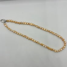 Load image into Gallery viewer, This apricot/gold color Freshwater pearl strand is very subtle and can easily be layered or worn on its own.  It features featuring 5 x7mm &#39;popcorn&#39; pearls with a Sterling Silver clasp and is fully knotted.  The length including clasp is 43cm.
