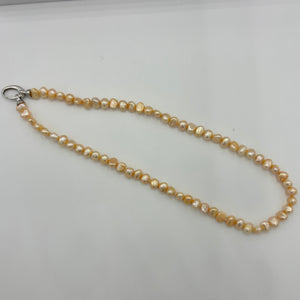 This apricot/gold color Freshwater pearl strand is very subtle and can easily be layered or worn on its own.  It features featuring 5 x7mm 'popcorn' pearls with a Sterling Silver clasp and is fully knotted.  The length including clasp is 43cm.