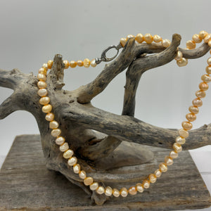 This apricot/gold color Freshwater pearl strand is very subtle and can easily be layered or worn on its own.  It features featuring 5 x7mm 'popcorn' pearls with a Sterling Silver clasp and is fully knotted.  The length including clasp is 43cm.