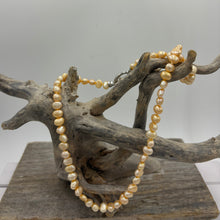 Load image into Gallery viewer, This apricot/gold color Freshwater pearl strand is very subtle and can easily be layered or worn on its own.  It features featuring 5 x7mm &#39;popcorn&#39; pearls with a Sterling Silver clasp and is fully knotted.  The length including clasp is 43cm.
