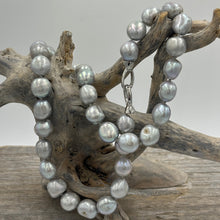 Load image into Gallery viewer, This stunning grey pearl strand is such a versatile color that goes with everything.  It features 11mm semi baroque shaped pearls and a sterling silver clasp.  The length including clasp is 46.5cm
