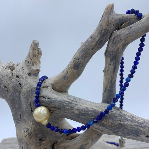 Golden South Sea pearl necklace with 3mm faceted Lapis gemstones and a sterling silver peanut clasp.

This necklace features a Circle Drop shape, 10.1mm x 11.9mm pearl that is  deep  Gold in colour. 

The small 3mm stones glow against the pearl and its overall length, including clasp, is 45cm

J3378