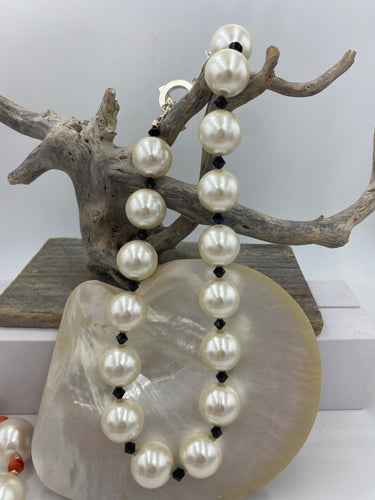 The Unique 90 year old Japanese glass pearls are very rare and very large at 20mm.

They have been combined with black agate beads to give the necklace depth. 

The stunning T Bar clasp is easy to use and finishes off this incredible statement piece

46cm in overall length 