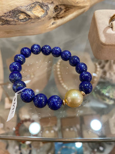 Australian South Sea Pearl Bracelet featuring 10mm natural Blue Lapis beads and with a Golden South Sea Pearl, Oval in shape, 12.6 x 13mm in size with high lustre  This bracelet is on strong 1mm elastic from US  J3312