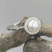 Load image into Gallery viewer, Sterling silver ring featuring an 7.5mm White freshwater&nbsp; Button shape pearl cradled inside a circle of Cubic Zirconia.

This ring has a non tarnish finish and comes in various sizes
