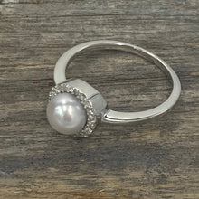 Load image into Gallery viewer, Sterling silver ring featuring an 7.5mm White freshwater&nbsp; Button shape pearl cradled inside a circle of Cubic Zirconia.

This ring has a non tarnish finish and comes in various sizes
