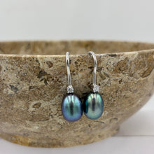 Load image into Gallery viewer, These elegant and classic Hook earrings are Sterling Silver and rhodium coated for a non tarnish finish and they feature a single claw set cubic zirconia above each pearl.

The pearls are drop shape, 9 x 12mm in size and Green with peacock hues in colour.

Also available with White or Pink pearls to order

