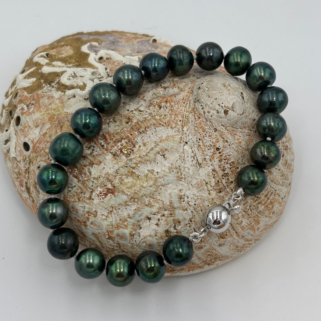 Stunning Freshwater pearl bracelet featuring round 9mm Peacock Green colour pearls and a sterling silver clasp.

Fully knotted with a 925 sterling silver clasp (non tarnish finish).

Length overall is 20cm
