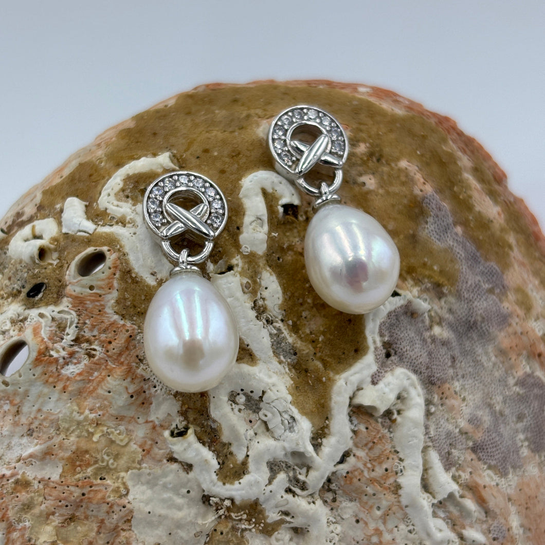 These fabulous stud style earrings are  925 sterling silver and rhodium coated for a non tarnish finish.

They feature an ornate stone set feature above the pearl. The pearls are 8.5mm white drop shape pearls of nice lustre.

The earrings measures 20mm from the top to the bottom