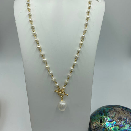 14ct gold plated over 925 sterling silver chain with a T-bar and loop closure.  Baroque white freshwater pearl , 12.5 x 16mm in size permanently attached to the loop  There are 52 white rice pearls, 4-5mm in size wired into the chain   Necklace is 52cm from T bar to the loop