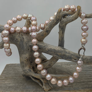 Freshwater pearl strand featuring shades of natural pink and lavender with high lustre.

This strand is 57cm long and the pearls are Round, 9-10.5mm in size with a stunning sterling silver clasp with a non tarnish finish