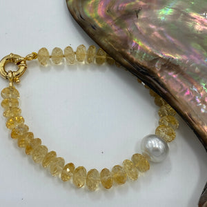 <p>Citrine bracelet featuring a white Australian South Sea Pearl</p> <p>Pearl is a button shape, and is 11.8mm in size and is white with silver pink hues in colour</p> <p>The Citrine beads are facetted button shaped and are 8.5 x 3.5mm in size</p> <p>This bracelet is knotted with a gold plated over sterling silver bolt ring clasp</p> <p>J3362</p>