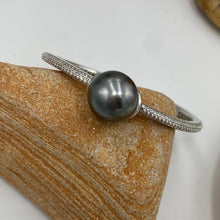 Load image into Gallery viewer, Sterling Silver solid bangle featuring a Tahitian South Sea Pearl

This stunning&nbsp; pearl&nbsp; is Tahitian and is Button in shape and 15mm in size.

It is Dark Green with Aubergine hues with High lustre and is featured on this rhodiun coated non tarnish bangle covered with pave set cubic zirconia&nbsp;

J3292
