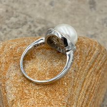 Load image into Gallery viewer, Stunning Sterling silver ring featuring an 11mm White freshwater&nbsp; Button shape pearl cradled in a Halo of&nbsp; Cubic Zirconia which also extend down the shank of the ring.

This ring has a non tarnish finish and comes in various sizes
