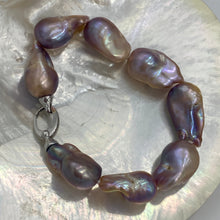 Load image into Gallery viewer, Stunning Freshwater pearl bracelet featuring Eight High lustre natural color Baroque pearls, stunning natural lavender, pink, apricot and Gold tones in colour and 14-25mm in size.

Fully knotted with a 925 sterling silver clasp (non tarnish finish).

Length overall is 21cm
