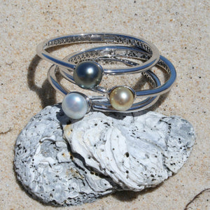 Sterling Silver solid bangle featuring a Tahitian South Sea Pearl  This stunning  pearl  is Tahitian and is Button in shape and 15mm in size.  It is Dark Green with Aubergine hues with High lustre and is featured on this rhodiun coated non tarnish bangle   J3292