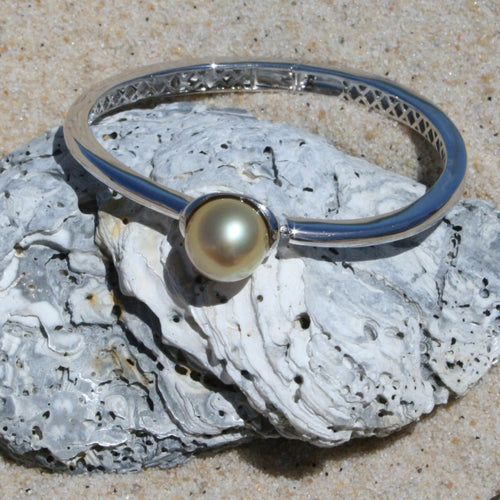 Sterling Silver solid bangle featuring an Indonesian South Sea Pearl  This stunning  pearl  is an Australian South Sea pearl,  Button in shape and 12.7mm in size. It is Deep Gold in color with High lustre and is featured on this rhodiun coated non tarnish bangle   J3294