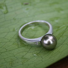 Load image into Gallery viewer, This stunning 925 sterling silver ring features a Semi Round Tahitian pearl, 9.2mm in size and Green with Aubergine tones in color. It has high lustre and glows  This ring design features two cubic zirconia one on either side of the pearl  It is rhodium coated 925 Sterling silver so will not tarnish   Size 56  J2932
