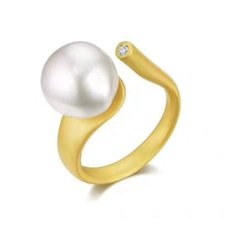 18ct Gold plated over 925 Sterling silver ring  It is satin finish and features Baroque to round 10mm White pearl and a Zircon  Adjustable ring band
